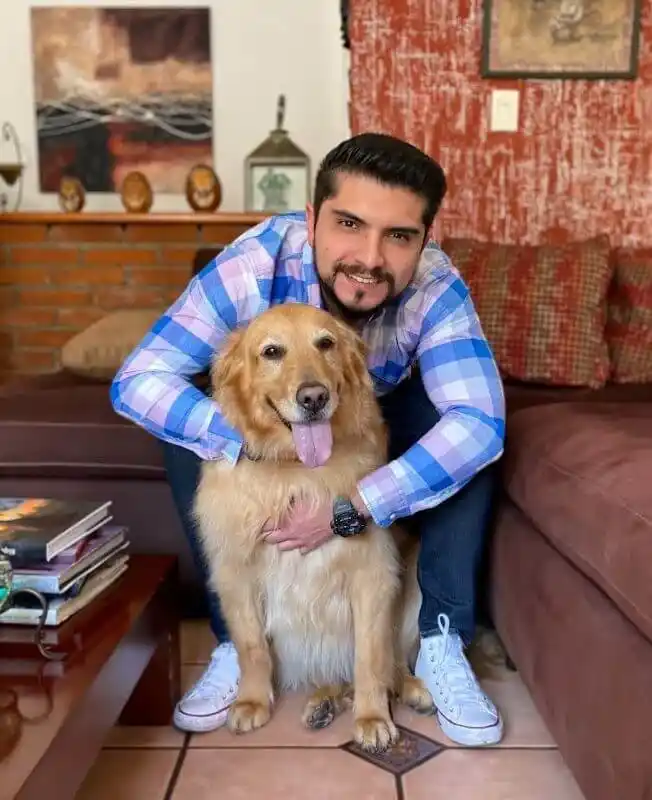 Consultor SEO sonriente en compañía de su perro Golden Retriever en su hogar.